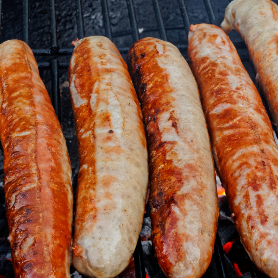 Gegrillte Würste in verschiedenen Farben auf dem Grill.